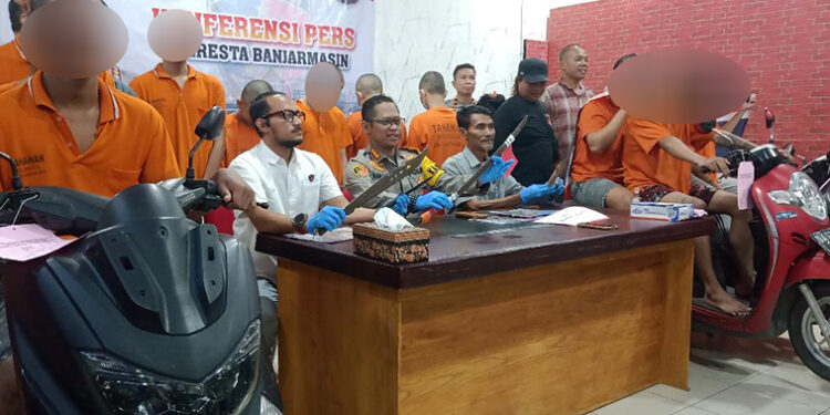 TUNJUKAN TERSANGKA - Kapolresta Banjarmasin Kombes Pol Sabana Atmojo Martosumito didampingi Kasat Reskrim Kompol Thomas Afrian dan Kanit Jatanras Iptu Avrus Husain saat menunjukan 12 tersangka geng motor beserta barbuk senjata tajam dan sepeda motor yang digunakan untuk mereka beraksi, Kamis (26/10).