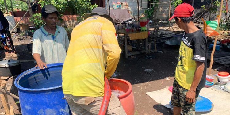 BAGIKAN AIR - Relawan Tagana Dinsos Kalsel ketika mengisi air bersih ke tempat penampungan sementara untuk dibagikan secara gratis kepada warga yang mengalami kesulitan air di Kabupaten Banjar.