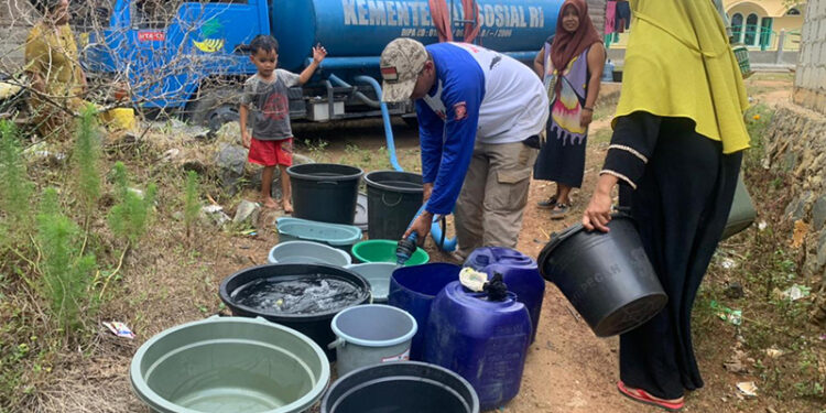 BAGIKAN AIR - Relawan Tagana Dinsos Kalsel saat membagikan air bersih gratis kepada warga terdampak kekeringan di Kabupaten Banjar, Sabtu (21/10). Sejak mulai mendistribusikan ke empat daerah di Kalsel pada 28 Agustus lalu, dinsos telah mendistribusikan sekitar 700 ribu liter air bersih.
