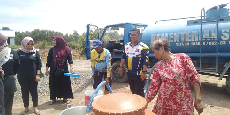 RELAWAN Tagana Dinas Sosial Kalsel ketika membagikan air bersih gratis kepada warga di Kabupaten Banjar, Selasa (17/10).
