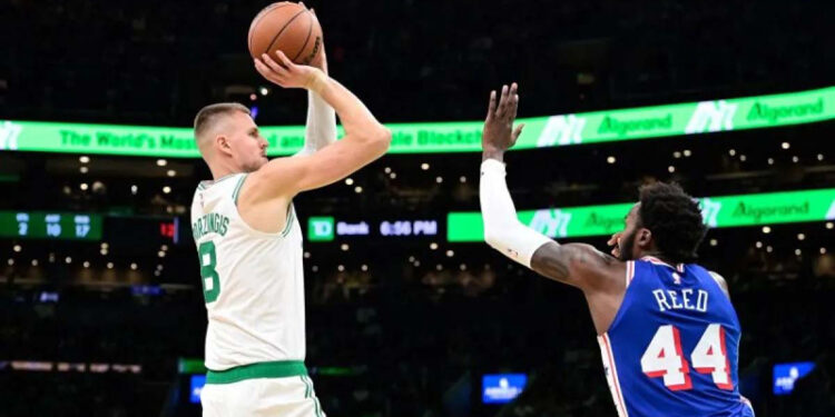 Pebasket Boston Celtics Kristaps Porzingis (kiri) berupaya memasukkan bola ke jaring lawan.