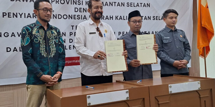 FOTO BERSAMA - Ketua Bawaslu Kalsel Aries Mardiono dan Ketua KPID Kalsel M Farid Soufian bersama anggotanya berfoto bersama usai penandatanganan kerja sama terkait pengawasan Pemilu 2024 di Aula Sekretariat Bawaslu Kalsel di Jalan RE Martadinata Banjarmasin, Senin (13/11) pagi.