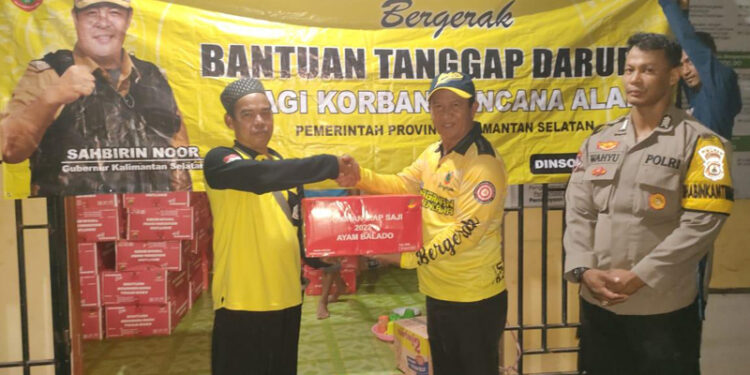 Sekretaris Dinas Sosial Provinsi Kalsel, Murjani ketika menyerahkan secara simbolis bantuan tanggap darurat Paman Birin (Gubernur Kalsel) untuk korban bencana angin puting beliung dan diterima Kepala Desa Beringin, Husin di lokasi kejadian