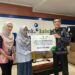 DIREKTUR Utama Bank Kalsel Fahrudin saat menyerahkan bantuan untuk mendukung program pembinaan kepada Agusliana Ketua Kampung Iklim RW 02 Kelurahan Sungai Miai.