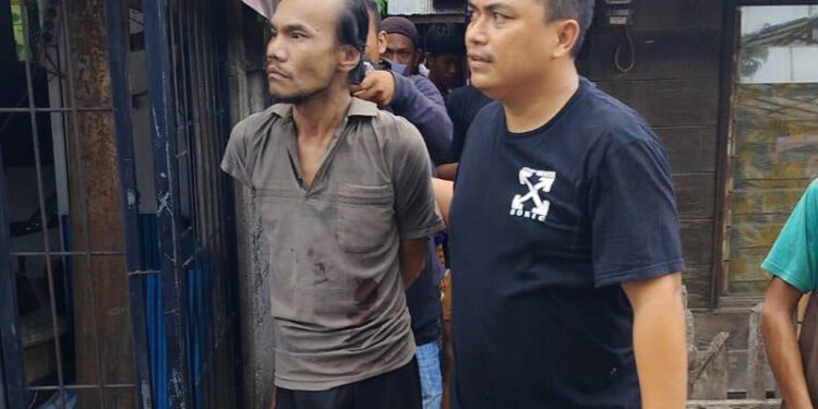 PETUGAS dari Sat Polairud Polresta Banjarmasin dibantu warga saat mengamankan pria mengamuk dengan senjata tajam di Alalak Selatan.