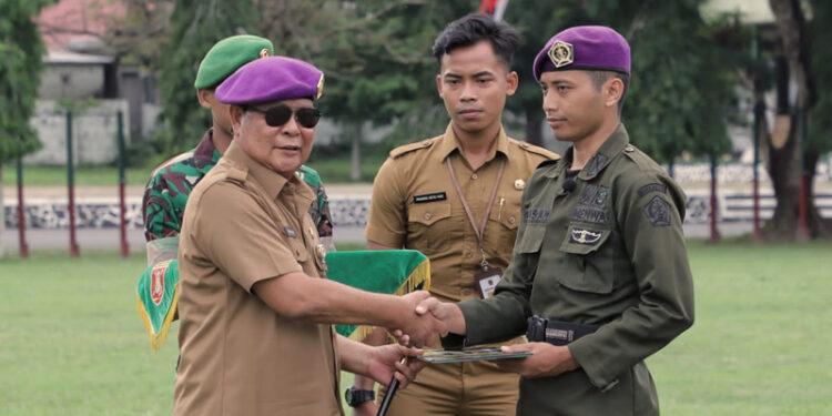 GUBERNUR Kalimantan Selatan H Sahbirin Noor ketika menyerahkan sertifikat Pendidikan Kursus Kader Pelaksana Nasional (Suskalaknas) Resimen Mahasiswa (Menwa) kepada seorang peserta kursus di Rindam VI Mulawarman, Banjarbaru, Senin (11/12).