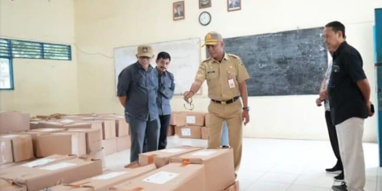 SEKDA Kabupaten Tanah Laut H Dahnial Kifli saat meninjau sortir dan pelipatan surat suara.