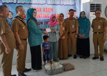 BAPAK ASUH-PJ Bupati Tapin M Syarifuddin MPd bersama ketua TP PKK Masrupah dan didampingi Asisten Ekobang H Errani Martin dan Staf Ahli Ekobang H Syafrudin SIP bersama Camat Lokpaikat Arie Wijaya sata menyerahkan bantuan bapak asuh anak stunting pada kunjungan Mojang Bastari di Kecamatan Lokpaikat, Selasa (09/01).