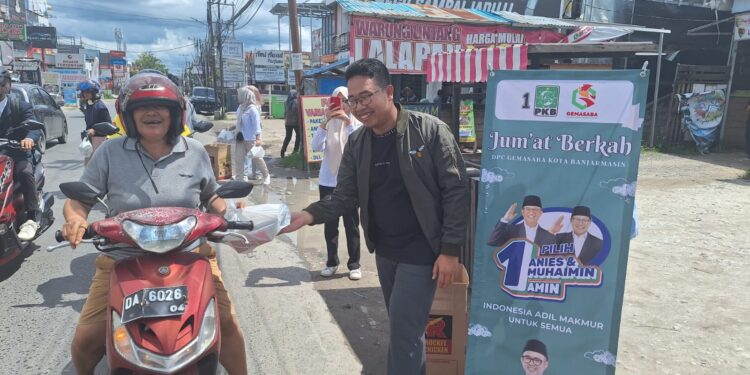 KETUA DPC Gemasaba Banjarmasin Ahmad Baihaqie saat membagikan nasi kotak gratis kepada pengendara roda dua di Jalan Sultan Adam Banjarmasin. (Foto: mb/edoy)