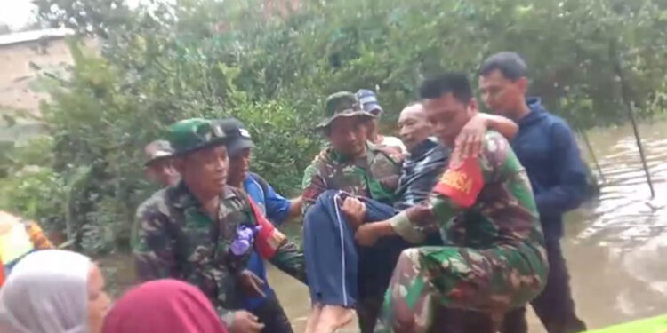 BABINSA saat menggendong seorang warga yang tengah sakit untuk pulang ke rumahnya, Selasa (16/1).