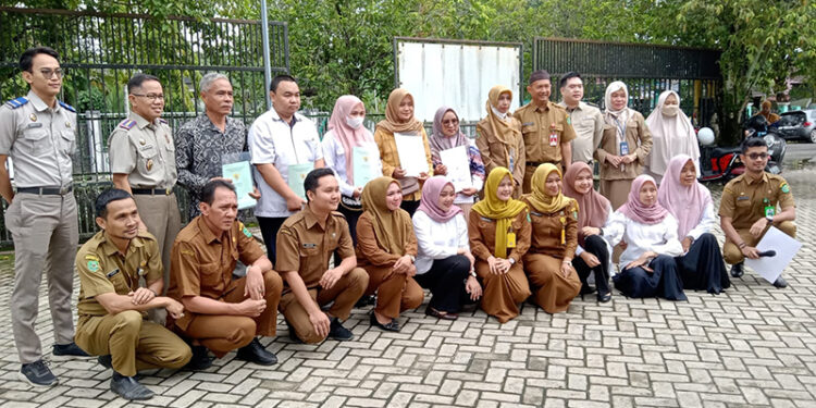 KADIS Perindustrian H Yustan Azidin ST MT bersama Kepala BPN Tapin Taufik Rokhman saat menyerahkan sertifikat lintas sektor kepada pelaku UMKM di Tapin, Senin (5/2).