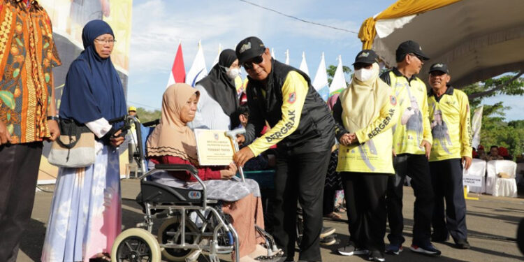 GUBERNUR Kalsel Sahbirin Noor memberikan hadiah tongkat kepada seorang penyandang disabilitas.
