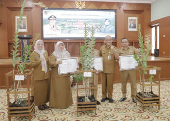 TERIMA PENGHARGAAN - Staf Ahli Gubernur Bidang Pemerintahan, Hukum dan Politik Adi Santoso dan Kepala Dinas Lingkungan Hidup Kalsel Hanifah Dwi Nirwana berfoto bersama penerima penghargaan perkantoran ramah lingkungan di lingkungan Pemprov Kalsel, Selasa (28/5).