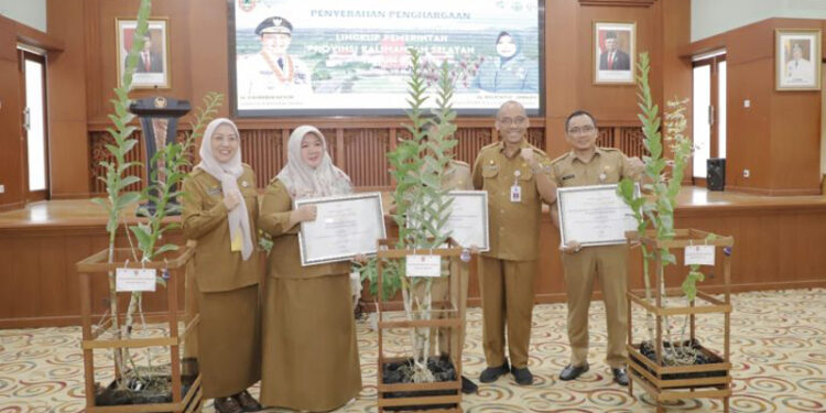 TERIMA PENGHARGAAN - Staf Ahli Gubernur Bidang Pemerintahan, Hukum dan Politik Adi Santoso dan Kepala Dinas Lingkungan Hidup Kalsel Hanifah Dwi Nirwana berfoto bersama penerima penghargaan perkantoran ramah lingkungan di lingkungan Pemprov Kalsel, Selasa (28/5).