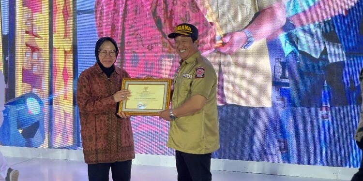Sekretaris Dinas Sosial Provinsi Kalimantan Selatan, Murjani, MPd ketika menerimakan penghargaan untuk Paman Birin (Gubernur Kalsel) dari Menteri Sosial (Mensos), Tri Rismaharini, di Aceh Utara.