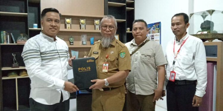 KEPALA DLH Tapin H Nordin berfoto bersama Kepala Cabang Asuransi BUMIDA Banjarmasin Syahrial Rifani usai penyerahan dokumen kerja sama, SeninĀ (6/5).