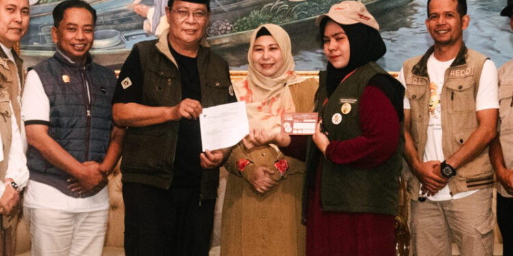 Gubernur Kalimantan Selatan, H Sahbirin Noor dan isteri, Hj Raudatul Jannah atau Acil Odah berfoto bersama petugas Coklit dan Pantarlih Martapura Timur, usai melaksanakan pencocokan data pemilih Pilkada 2024