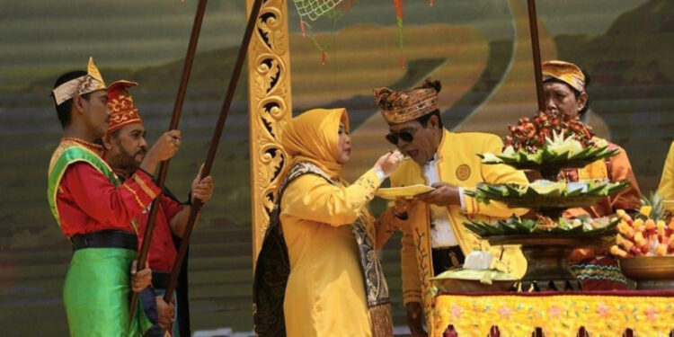 GBUBERNUR Kalimantan Selatan H Sahbirin Noor saat menerima suapan nasi astakona dari Ketua Tim Penggerak PKK Provinsi Kalsel Hj Raudatul Jannah atau Acil Odah pada puncak peringatan Hari Jadi ke-74 Provinsi Kalimantan Selatan tahun 2024.