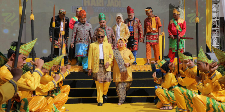 DISAMBUT MAMANDA – Gubernur Kalsel H Sahbirin dan istrinya, Hj Raudatul Jannah atau Acil Odah disambut para pemain kesenian Mamanda, saat menghadiri acara puncak Hari Jadi ke-74 Provinsi Kalsel yang berlangsung di halaman Kantor Gubernur Lama di Banjarmasin, Rabu (14/8) pagi.