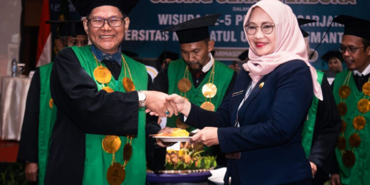 Staf Ahli Gubernur Bidang Kemasyarakatan dan SDM, Hj Husnul Khatimah saat menerima nasi tumpeng pada Wisuda ke-5 dan Dies Natalis ke-10 Universitas Nahdlatul Ulama (UNU) Kalsel