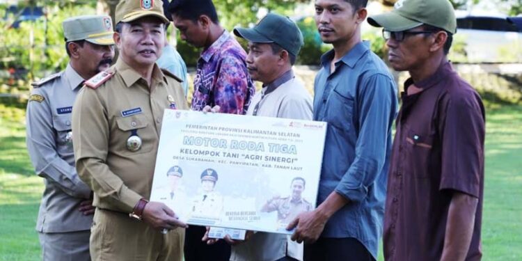Pj Sekdaprov Kalimantan Selatan, Muhammad Syarifuddin saat menyerahkan fasilitas bantuan kegiatan alat sarana prasarana holtikultura berupa motor roda tiga kepada perwakilan kelompok tani (Poktan) di Kalsel
