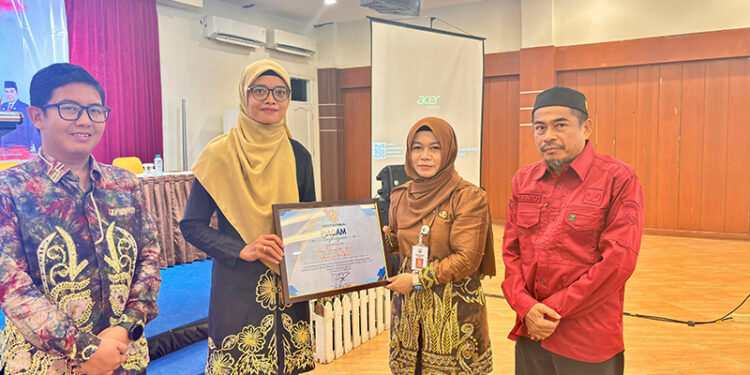 STAF Ahli Bidang Kemasyarakatan dan SDM Jurainah saat menyerahkan piagam penghargaankepada KPU dan Bawaslu Kotabaru, Kamis (21/8).