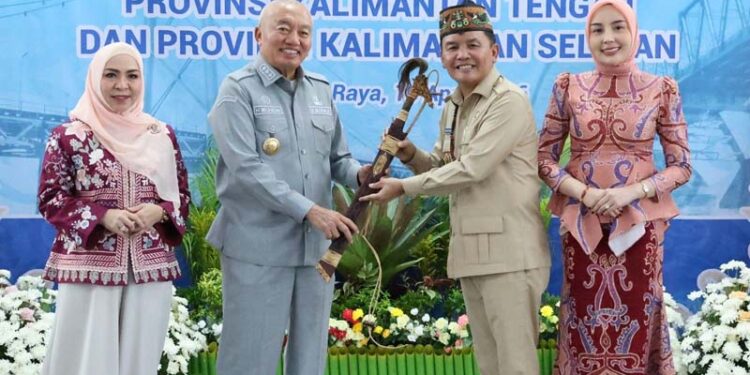 CINDERAMATA - Gubernur Kalimantan Selatan, H Muhidin didampingi istri, Hj Fathul Jannah menerima cinderamata berupa mandau dari Gubernur Kalimantan Tengah, H Agustiar Sabran di sela pertemuan kedua kepala daerah tersebut di Palangka Raya, Kalteng.