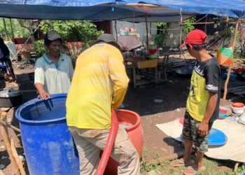 BAGIKAN AIR - Relawan Tagana Dinsos Kalsel ketika mengisi air bersih ke tempat penampungan sementara untuk dibagikan secara gratis kepada warga yang mengalami kesulitan air di Kabupaten Banjar.