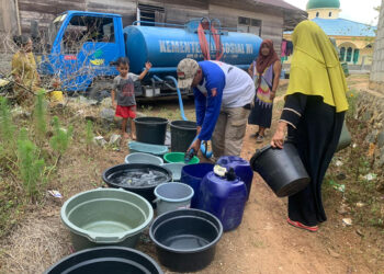 BAGIKAN AIR - Relawan Tagana Dinsos Kalsel saat membagikan air bersih gratis kepada warga terdampak kekeringan di Kabupaten Banjar, Sabtu (21/10). Sejak mulai mendistribusikan ke empat daerah di Kalsel pada 28 Agustus lalu, dinsos telah mendistribusikan sekitar 700 ribu liter air bersih.
