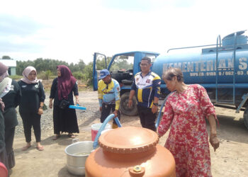 RELAWAN Tagana Dinas Sosial Kalsel ketika membagikan air bersih gratis kepada warga di Kabupaten Banjar, Selasa (17/10).