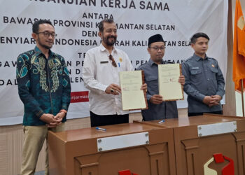 FOTO BERSAMA - Ketua Bawaslu Kalsel Aries Mardiono dan Ketua KPID Kalsel M Farid Soufian bersama anggotanya berfoto bersama usai penandatanganan kerja sama terkait pengawasan Pemilu 2024 di Aula Sekretariat Bawaslu Kalsel di Jalan RE Martadinata Banjarmasin, Senin (13/11) pagi.