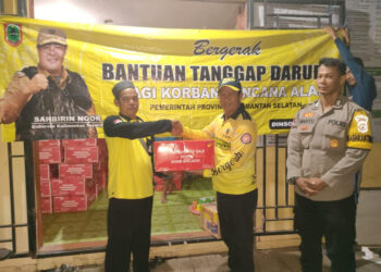 Sekretaris Dinas Sosial Provinsi Kalsel, Murjani ketika menyerahkan secara simbolis bantuan tanggap darurat Paman Birin (Gubernur Kalsel) untuk korban bencana angin puting beliung dan diterima Kepala Desa Beringin, Husin di lokasi kejadian