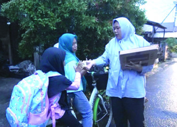 Bendahara TKD Prabowo-Gibran Kalsel Hj Mariana saat membagikan makanan siang dan susu gratis ke masyarakat.