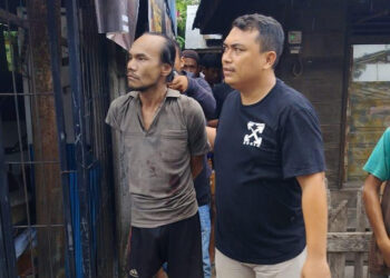 PETUGAS dari Sat Polairud Polresta Banjarmasin dibantu warga saat mengamankan pria mengamuk dengan senjata tajam di Alalak Selatan.
