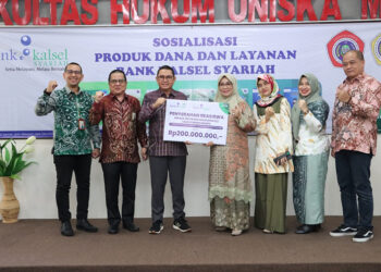 DIREKTUR Operasional Bank Kalsel Ahmad Fatrya Putra saat menyerahkan bantuan beasiswa ke Ketua Badan Pembina Yayasan Uniska Hj Rahmi Hayati Tadjudinnoor.