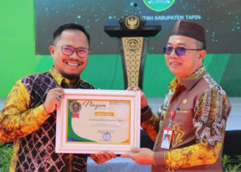 TERIMA PIAGAM-Penjabat Bupati Tapin Syarifuddin menerima Piagam UHC dari BPJS Kesehatan di Rantau, Kalimantan Selatan.