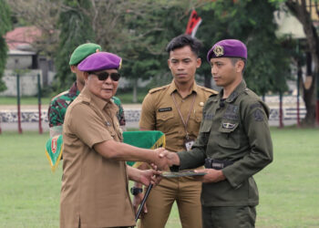 GUBERNUR Kalimantan Selatan H Sahbirin Noor ketika menyerahkan sertifikat Pendidikan Kursus Kader Pelaksana Nasional (Suskalaknas) Resimen Mahasiswa (Menwa) kepada seorang peserta kursus di Rindam VI Mulawarman, Banjarbaru, Senin (11/12). 
