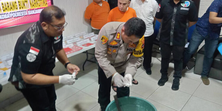 MUSNAHKAN - Wakapolresta Banjarmasin AKBP Arwin Amrih Wientama didampingi Kasat Resnarkoba Polresta Banjarmasin Kompol Bala P Dewa saat melakukan pemusnahan barbuk narkoba, Rabu (24/1).