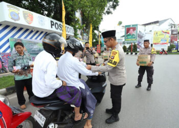 BANJARMASIN - Kapolresta Banjarmasin Kombes Pol Sabana Atmojo membagikan 1.500 snack dan 200 nasi bungkus ke para jamaah Haul ke-19 Muhammad Zaini bin Abdul Ghani atau Abah Guru Sekumpul kepada masyarakat pengguna jalan raya.