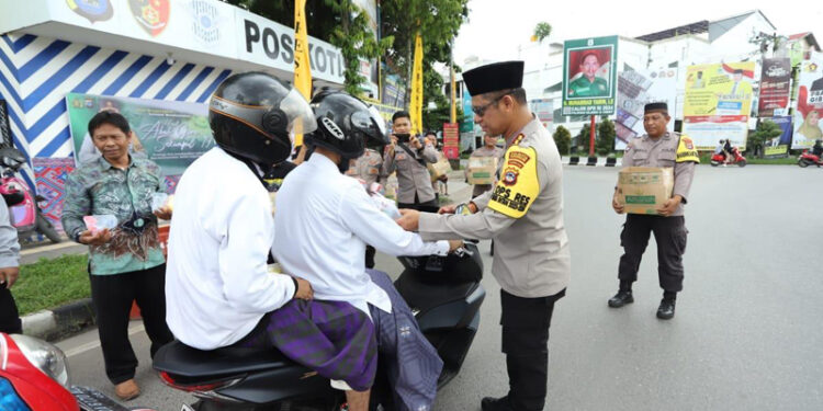 BANJARMASIN - Kapolresta Banjarmasin Kombes Pol Sabana Atmojo membagikan 1.500 snack dan 200 nasi bungkus ke para jamaah Haul ke-19 Muhammad Zaini bin Abdul Ghani atau Abah Guru Sekumpul kepada masyarakat pengguna jalan raya.