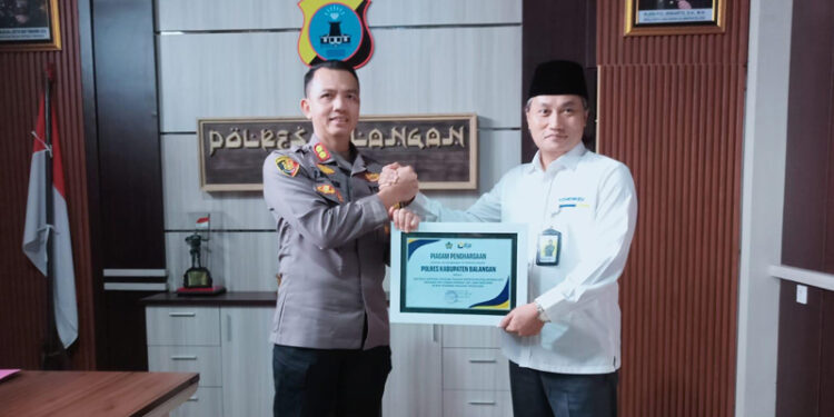 KAPOLRES Balangan AKBP Riza Muttaqin saat menerima penghargaan wajib pajak dari Kepala KPP Pratama Tanjung Mulyono Purwo Wijoyo.