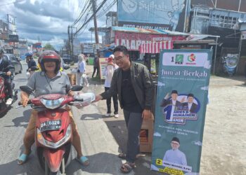 KETUA DPC Gemasaba Banjarmasin Ahmad Baihaqie saat membagikan nasi kotak gratis kepada pengendara roda dua di Jalan Sultan Adam Banjarmasin. (Foto: mb/edoy)