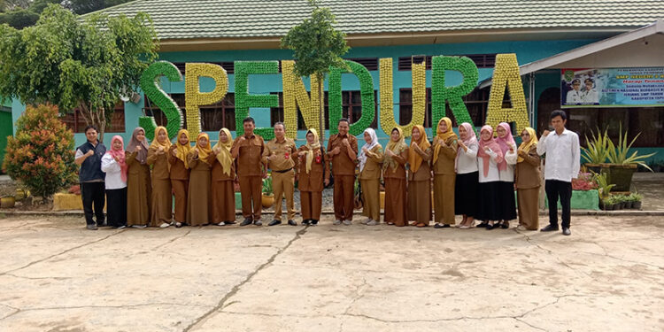 PJ Bupati Tapin M Syarifuddin MPd bersama Kepala Dinas Pendidikan Hj Irnawati SPd MM berfoto bersama usai mengunjungi SMPN 2 Tapin.