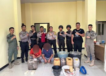 PETUGAS saat menunjukan pelaku dan barang bukti minuman beralkohol jenis Tuak.