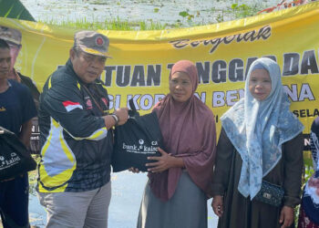 Kabid Penanganan Bencana pada Dinas Sosial Provinsi Kalimantan Selatan, H Achmadi, SSos saat menyerahkan bantuan sembako dari Bank Kalsel dan Paman Birin untuk korban bencana alam banjir di Kecamatan Kalumpang, Kabupaten Hulu Sungai Selatan (HSS).