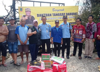 Kepala Seksi (Kasi) Perlindungan Sosial Korban Bencana Sosial, Bidang Penanganan Bencana, Yovie berfoto bersama warga usai penyerahan bantuan tanggap darurat untuk korban kebakaran di Berangas Timur, Kecamatan Alalak, Kabupaten Batola.