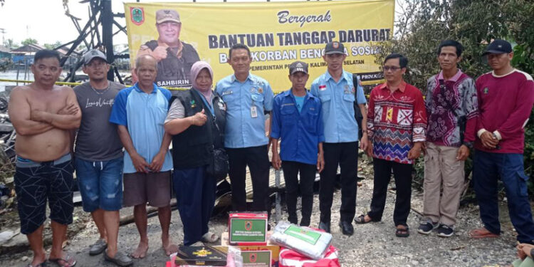 Kepala Seksi (Kasi) Perlindungan Sosial Korban Bencana Sosial, Bidang Penanganan Bencana, Yovie berfoto bersama warga usai penyerahan bantuan tanggap darurat untuk korban kebakaran di Berangas Timur, Kecamatan Alalak, Kabupaten Batola.