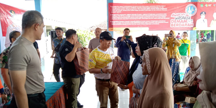 PJ Bupati Tapin M Syarifuddin MPd bersama Kapolres AKBP Sugeng Priyanto SIK dan pimpinan SOPD serta camat saat menyerahkan bantuan untuk keluarga yang telah sembuh dari BDB di Desa Baringin A.