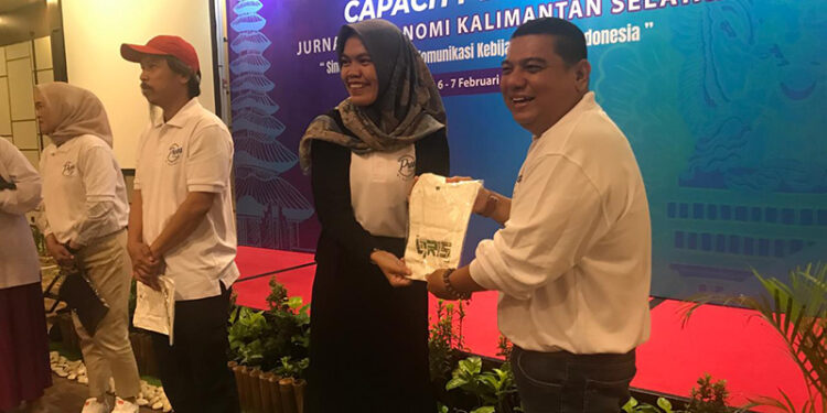 PENGAWAS Sistem Pembayaran-Pengelolaan Uang Rupiah Bank Indonesia Kalsel Dewi Rahmawati menyerahkan hadiah kepada peserta Capacity Building Jurnalis Ekonomi Kalsel.