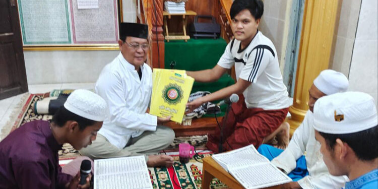 Gubernur Kalimantan Selatan, H Sahbirin Noor saat menyerahkan bantuan Alquran disela melaksanakan tadarusan Alquran bersama warga di masjid dan Mushalla.